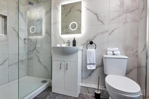 a bathroom with a toilet and a shower and a sink at Homebird Property - Haddon House in Leeds