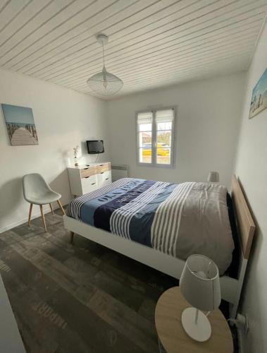une chambre avec un lit, un bureau et une chaise dans l'établissement Petite maison au calme, dans une impasse, à LʼÉpine