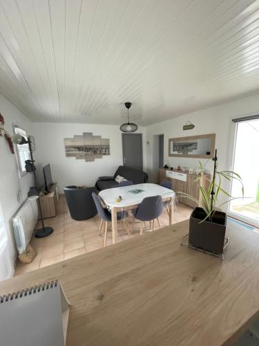 a dining room and living room with a table and chairs at Petite maison au calme, dans une impasse in LʼÉpine