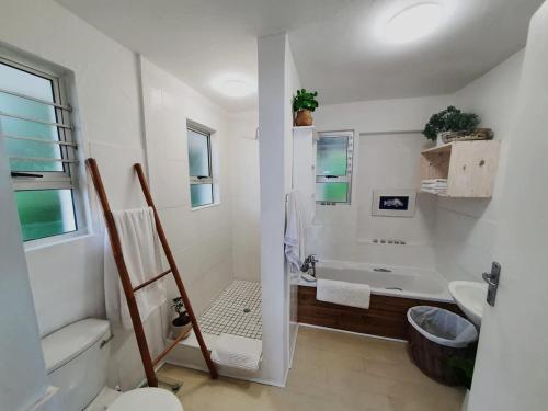 a bathroom with a tub and a toilet and a sink at Cottage On the Beach in Umdloti