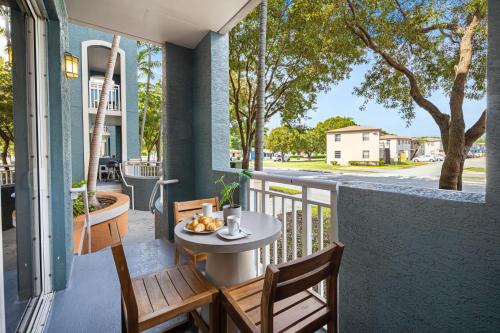 a balcony with a table and chairs on a porch at Dharma Home Suites South Miami at Red Road Commons in Miami