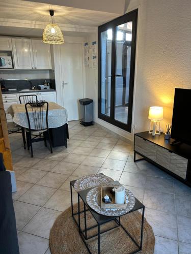 uma sala de estar com uma mesa e uma cozinha em la maison des sables 4 port leucate em Port Leucate