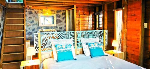 1 dormitorio con 1 cama con almohadas azules y blancas en Maison Harmonie Atypique, en Saint-Leu