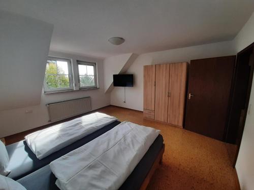 - une chambre avec un grand lit et une télévision dans l'établissement Ferienwohnung Dorfengel, à Berolzheim