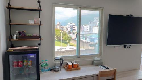 a room with a large window and a television at Green Stay in Hualien City