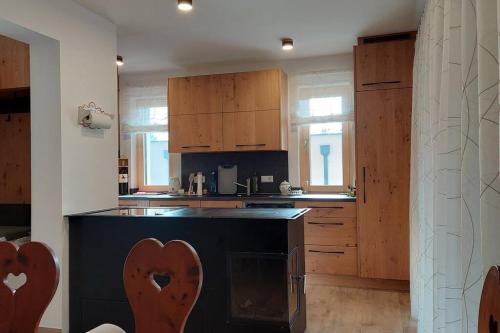 a kitchen with a black counter and wooden cabinets at Siedls Enzian in Hirschegg Rein