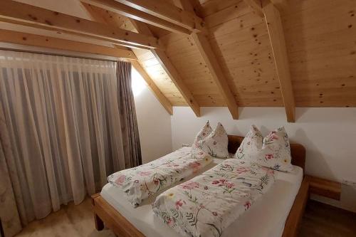 een slaapkamer met een bed met witte lakens en kussens bij Siedls Enzian in Hirschegg Rein