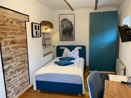 um quarto com uma cama azul com almofadas azuis em Ferienhaus Burgblick in Stadtschlaining em Stadtschlaining