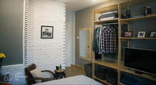 a bedroom with a bed and a tv and a wall at Deluxe Room have Balcony D1-Dakao in Ho Chi Minh City