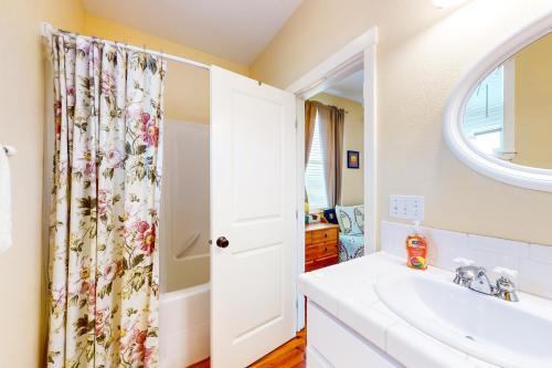 uma casa de banho com um lavatório e um espelho em The Yellow Rose House em Lincoln City