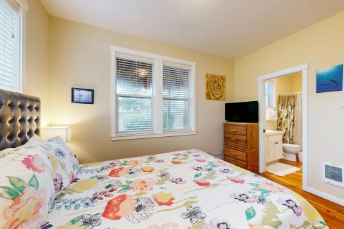 a bedroom with a bed and a flat screen tv at The Yellow Rose House in Lincoln City