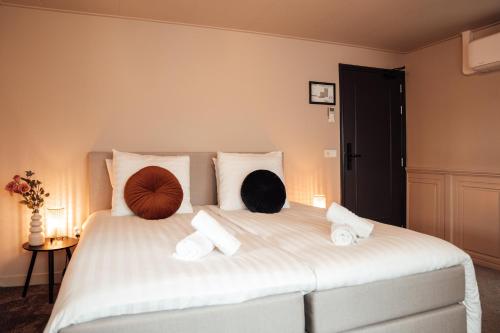 a bedroom with a large white bed with pillows on it at Hotel bij Jacob in Enschede