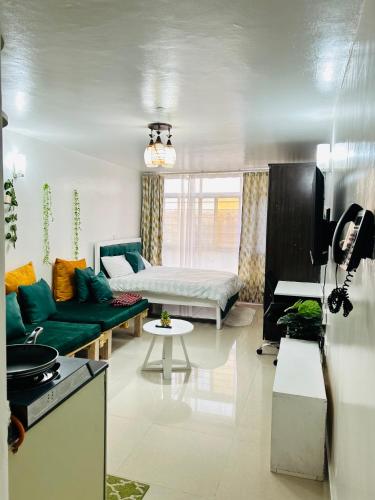 uma sala de estar com um sofá e uma cama em Emerald BnB em Ruaka