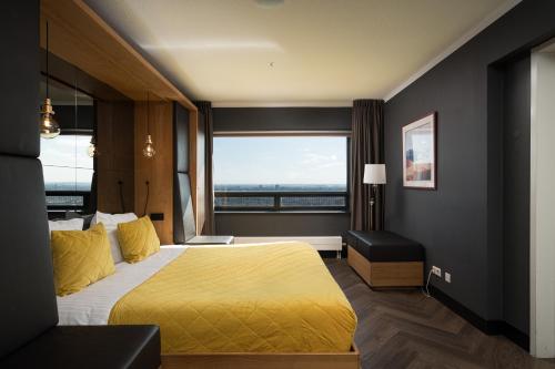 a hotel room with a bed and a large window at The Penthouse At The Hague Tower in The Hague