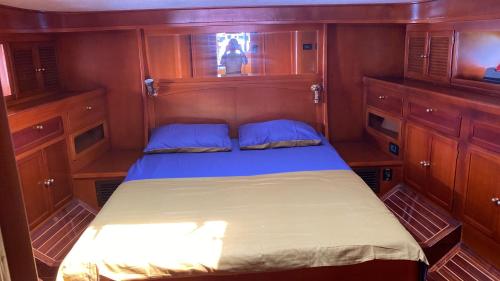 a bed in a small room with wooden cabinets at PRUVA YACHT in Istanbul