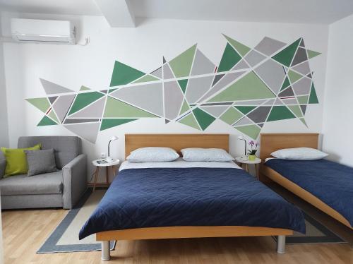 a bedroom with two beds and a geometric wall at Apartment Stipčić-Mrežnički Brig in Duga Resa