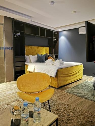 a bedroom with a large bed with two chairs and water bottles at Hill Valley Asilah - Luxury Living & Boutique Hotel in Asilah