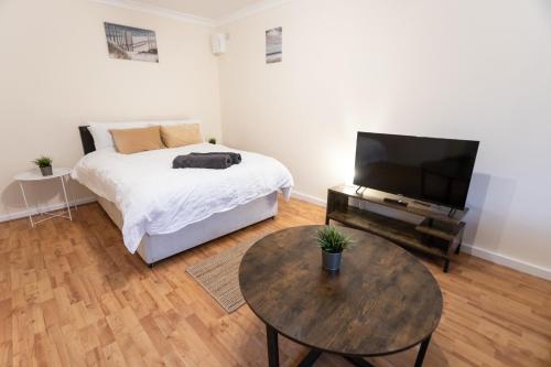 um quarto com uma cama e uma mesa com uma televisão em May Disc - Long Stay - Contractors em Bristol