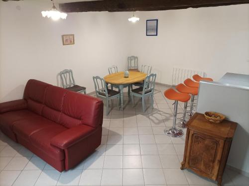 a living room with a couch and a table and chairs at La petite Corbières in Roquefort-des-Corbières