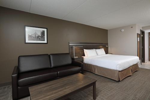 a hotel room with a bed and a couch at Canad Inns Destination Centre Brandon in Brandon