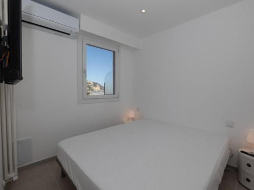 a white bedroom with a bed and a window at Appartement Menton, 2 pièces, 4 personnes - FR-1-196-340 in Menton