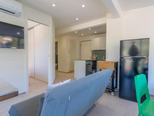 un salon avec un canapé bleu et une cuisine dans l'établissement Joli 2P calme refait à neuf avec terrasse, WiFi et parking - FR-1-196-340, à Menton