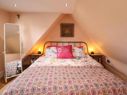 a bedroom with a large bed with red pillows at The Granary Owl House in Gainsborough