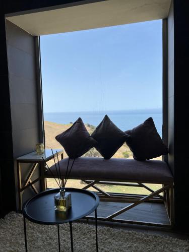 a couch on a balcony with a view of the ocean at Hill Valley Asilah - Luxury Living & Boutique Hotel in Asilah