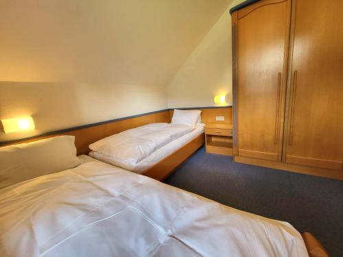 a bedroom with two beds and a cupboard and a bed at Appartements Höller in Sankt Lorenzen ob Murau