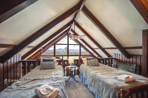 a attic room with two beds and a window at Cozy Mountain-View Escape, 1 Mi to Beech Mountain! in Beech Mountain