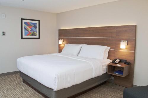 a hotel room with a large bed and a telephone at Holiday Inn Express South Burlington by IHG in Burlington