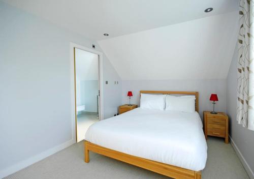 a bedroom with a white bed and a large mirror at The Oars - Riverfront Property in Henley on Thames