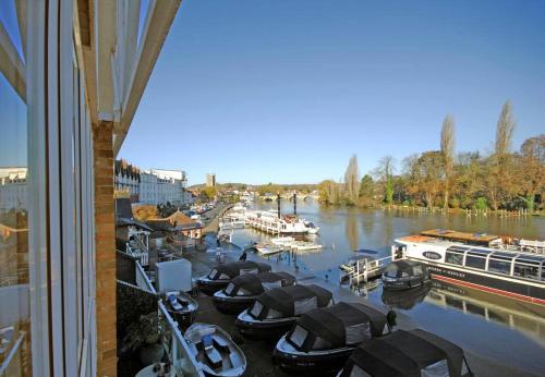 a group of boats are docked in a marina at The Oars - Riverfront Property in Henley on Thames