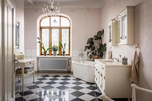 baño con bañera, 2 lavabos y ventana en Vita huset, en Gärsnäs