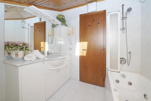 een witte badkamer met een wastafel en een douche bij iFlat Madonna di Campiglio Penthouse Brenta in Madonna di Campiglio