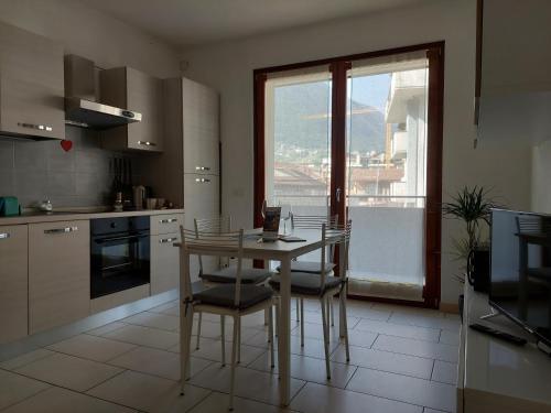 una cucina con tavolo, sedie e finestra di Bilocale luminoso, ottima posizione, wi-fi e sky a Sondrio