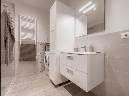 ein weißes Badezimmer mit einem Waschbecken und einem Spiegel in der Unterkunft Realkasa Ferriera C in Bologna