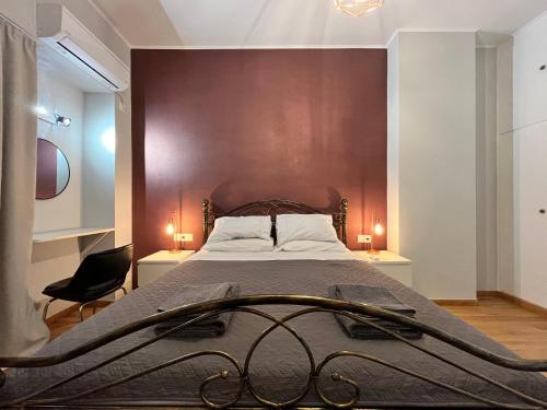- une chambre avec un grand lit et un mur marron dans l'établissement Deseo Apartments, à Athènes
