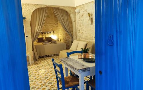 een kamer met een tafel en een slaapkamer met een bed bij Casa Mirabilis 44 in Ostuni