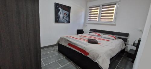 Schlafzimmer mit einem Bett mit roter und weißer Bettwäsche in der Unterkunft au petit canal de Colmar 3 in Kunheim