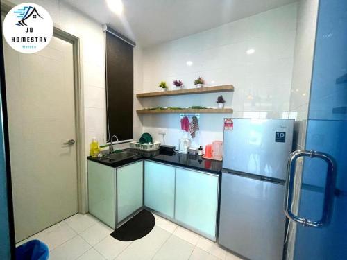 a kitchen with a sink and a refrigerator at New SeaView Residences @ 2 Rooms (Near Jonker) in Melaka