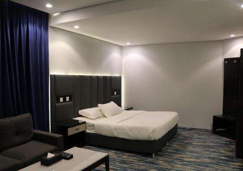 قمم بارك Qimam Park Hotel 1 في أبها: غرفه فندقيه بسرير وكرسي