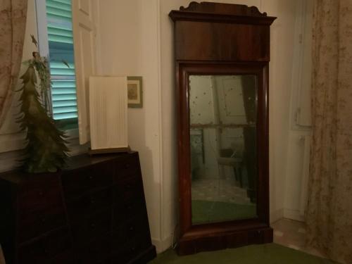 a mirror in a room with a dresser and a window at La Marquise in Bastia