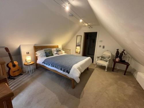 a bedroom with a bed and a guitar in a attic at The Engine House in Truro