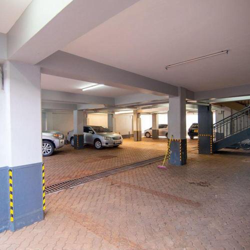 uma garagem vazia com carros estacionados nela em The Green Apartment em Ruaka
