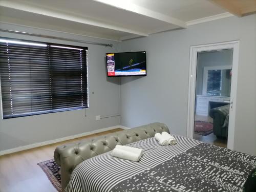 um quarto com uma cama e uma televisão na parede em 20 On Percy na Cidade do Cabo