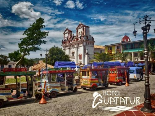 a group of trucks parked in front of a building at Hotel Guatatur in Guatapé