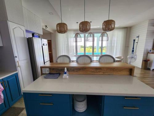 a kitchen with a counter with chairs and a refrigerator at Villa Pacifica in Nasugbu