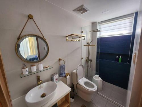 a bathroom with a sink and a toilet and a mirror at Villa Pacifica in Nasugbu