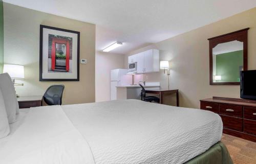 a hotel room with a large bed and a kitchen at Studio 6 Extended Stay Huntsville, AL - US Space & Rocket Center in Huntsville